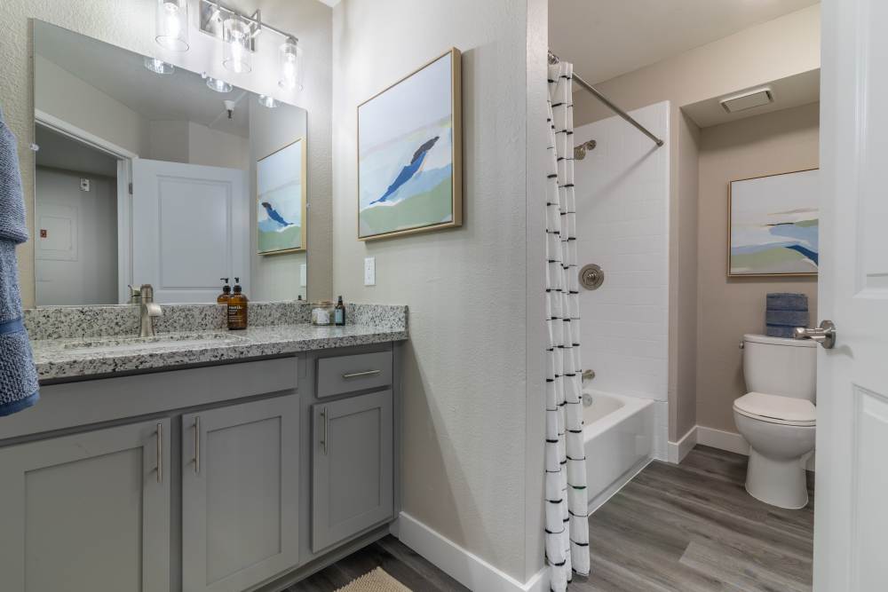 Bathroom with a large mirror at Gateway Apartments in San Leandro, California