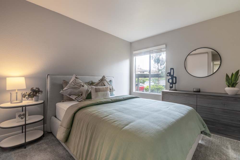 Bedroom with a large window at Gateway Apartments in San Leandro, California