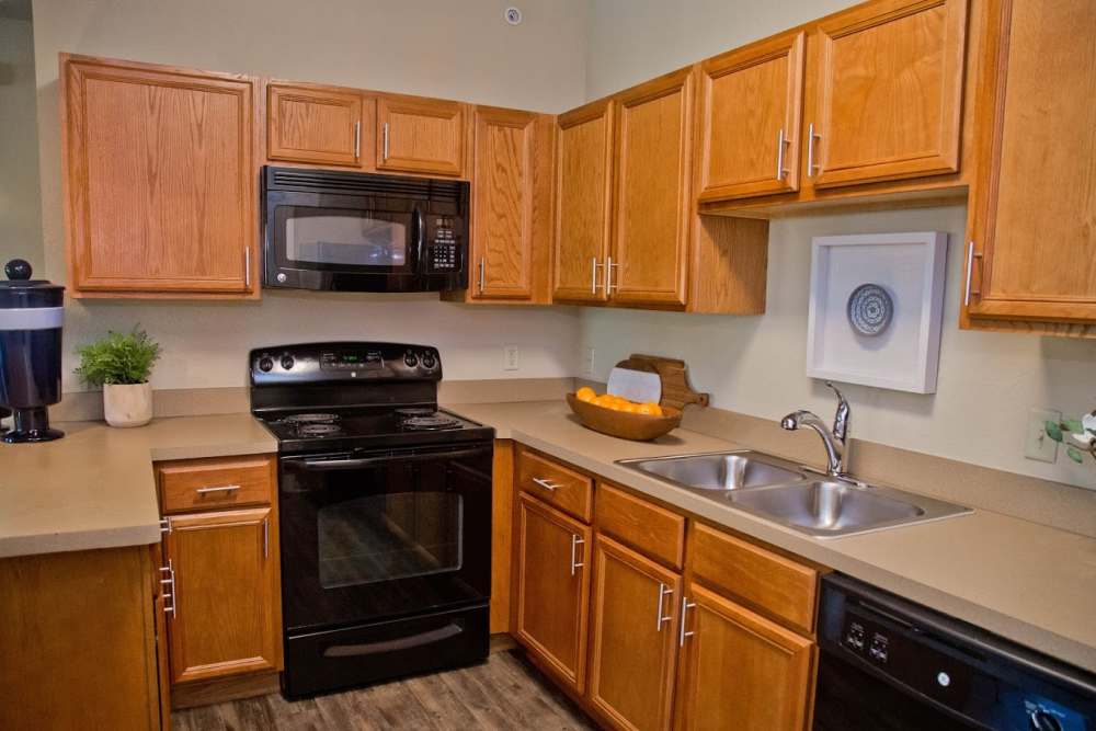Kitchen with wooden cabinets at The Manor Homes of Eagle Glen in Raymore, Missouri