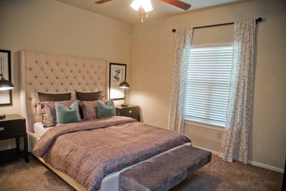 Cozy bedroom with a large window at The Manor Homes of Eagle Glen in Raymore, Missouri