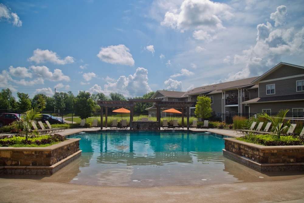 Resort-style swimming pool with multiple lounge chairs at The Manor Homes of Eagle Glen in Raymore, Missouri