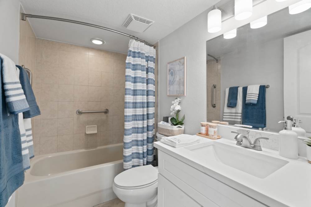 Apartment bathroom with quartz counter and shower tub combo at Waters Pointe in South Pasadena, Florida