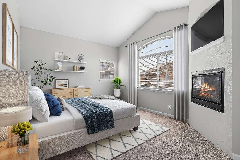 Naturally lit, spacious bedroom with cozy fireplace at Isabella Apartment Homes in Greenwood Village, Colorado