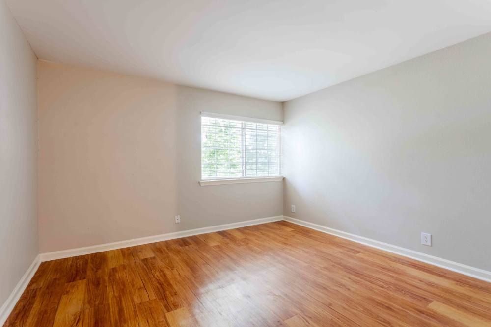 Empty room featuring hardwood floors and white walls, creating a bright and spacious atmosphere at 865 Bellevue Apartments in Nashville, Tennessee