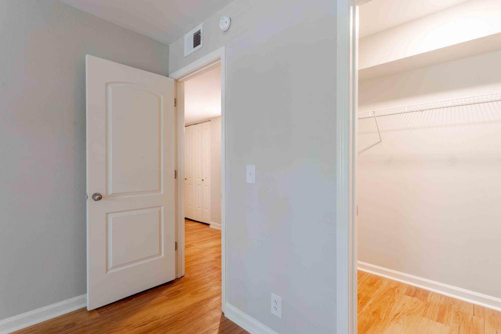 A room featuring a closet and a door, with neutral-colored walls and simple furnishings at 865 Bellevue Apartments in Nashville, Tennessee