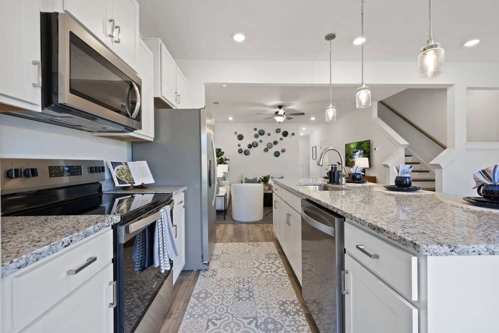 Modern kitchen with white cabinets and granite countertops at Artisan Living Mills River in Mills River, North Carolina