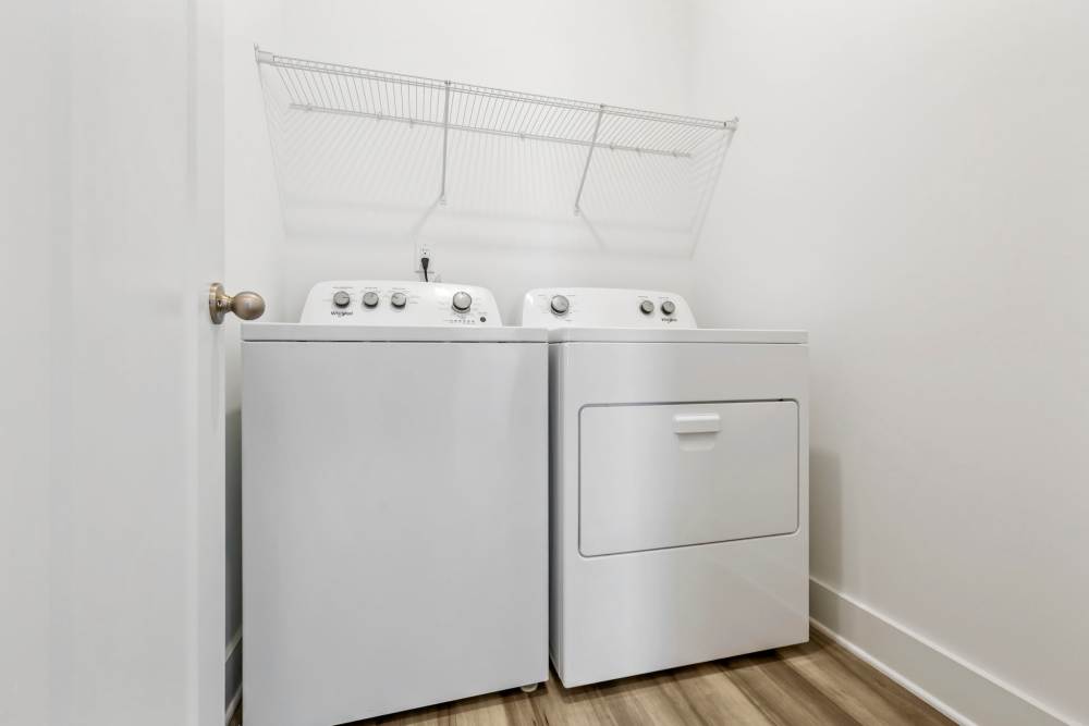 Laundry area with overhead storage shelf at Artisan Living Mills River in Mills River, North Carolina