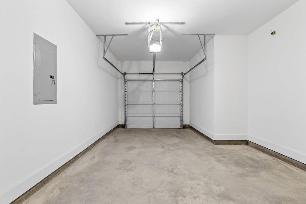 Clean garage space with concrete flooring and automatic door at Artisan Living Mills River in Mills River, North Carolina