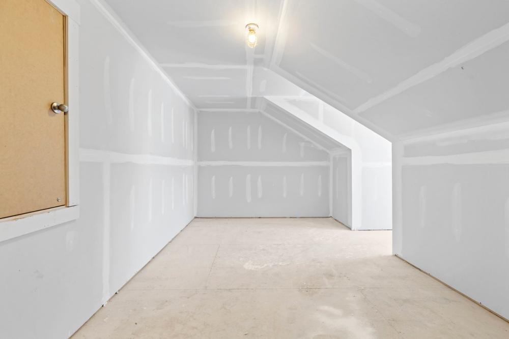 Upper-level room with sloped ceiling and basic wall finishes at Artisan Living Mills River in Mills River, North Carolina