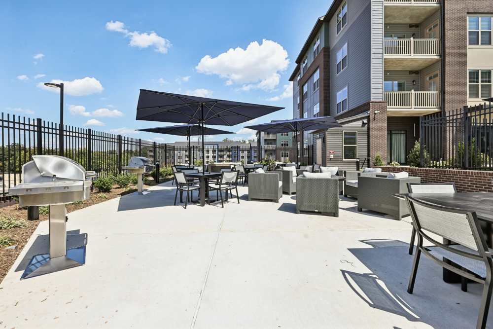 Outdoor resident lounge with seating and grilles at Elms Shady Grove in Rockville, Maryland
