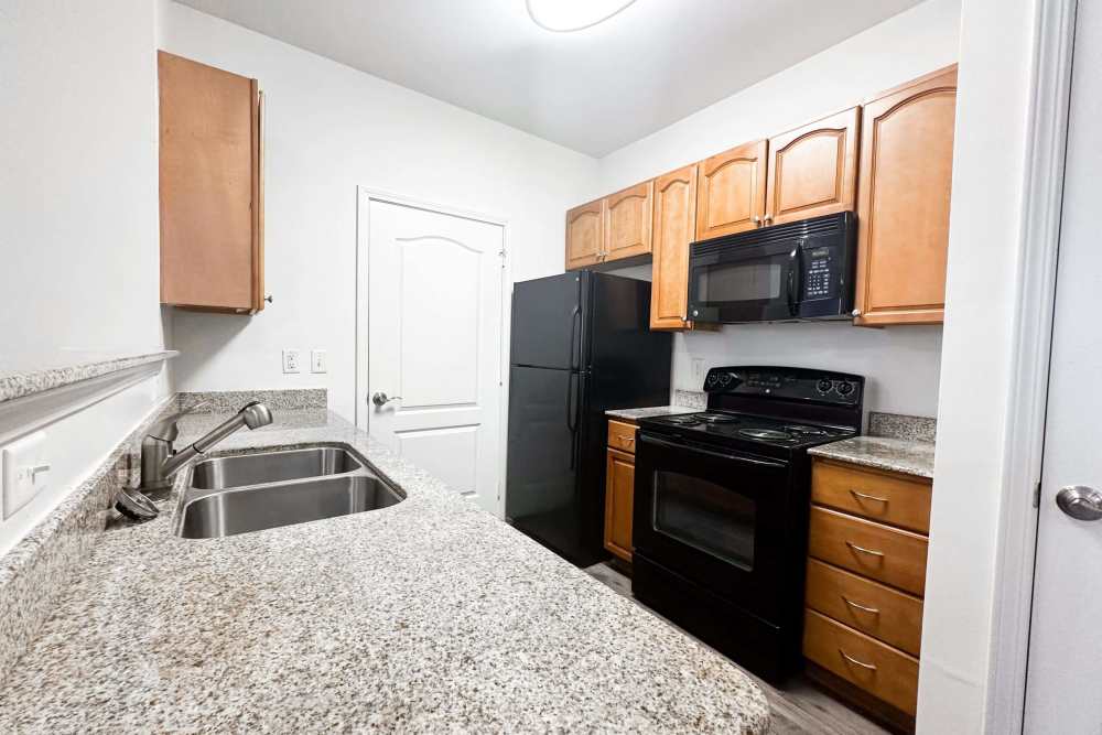 Cozy kitchen with mosaic countertop and black appliances at Windsor Upon Stonecrest in Burlington,North Carolina