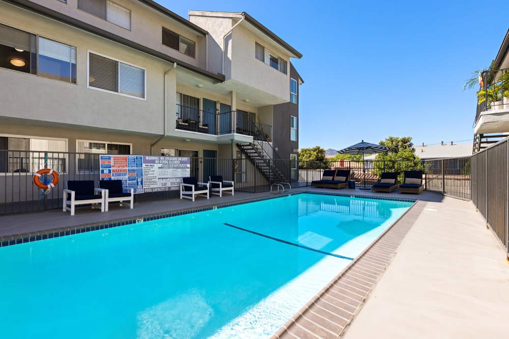 Resort-style pool with lounge chairs surrounded by lush woodlands at The Indie Glendale Collection, Glendale, California