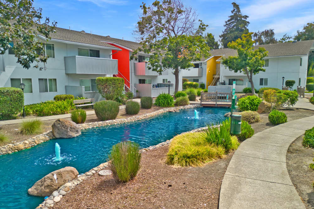 Apartment exterior with a nearby pond at Lakeside Village in San Leandro, California