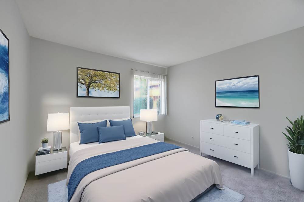 Bedroom with dresser and bedside lamp at Lakeside Village in San Leandro, California