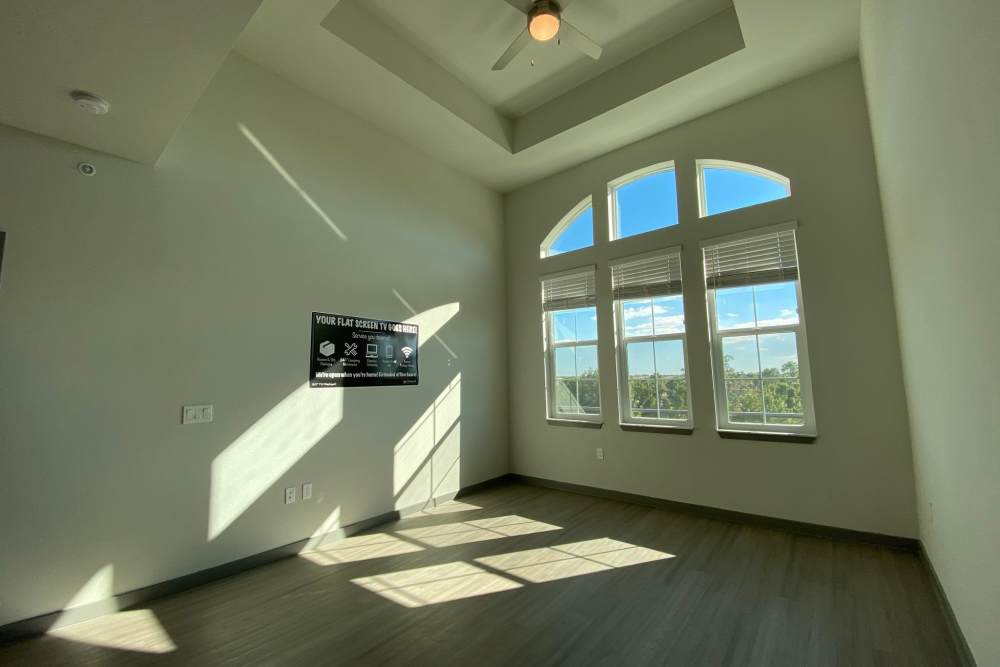 Unfurnished apartment bedroom with wood-style flooring and a large window at Murano at Three Oaks in Fort Myers,Florida
