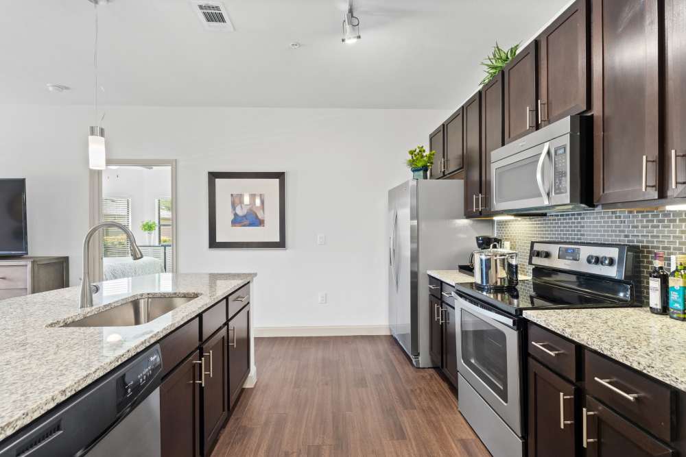 Spacious kitchen with wood-style flooring at The Abbey at Preserve Way in Tomball, Texas
