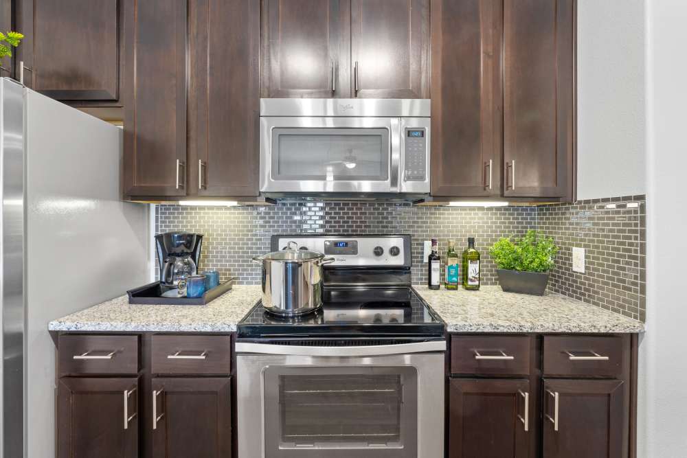 Modern kitchen with stainless-steel appliances at The Abbey at Preserve Way in Tomball, Texas