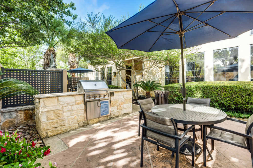 Lounge chairs and tables and a grill at The Quarry Townhomes in San Antonio, Texas