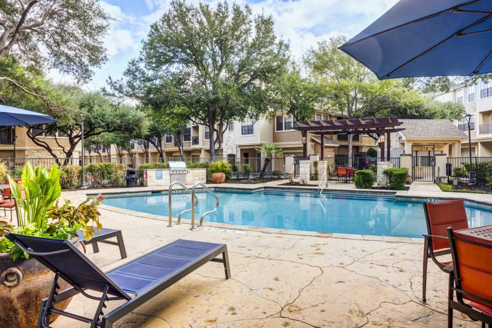 Lounge chairs next to the pool at The Quarry Townhomes in San Antonio, Texas