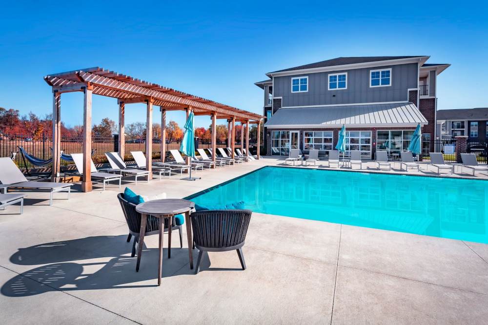 Pool with chairs at Flats at Stones Crossing in Greenwood, Indiana