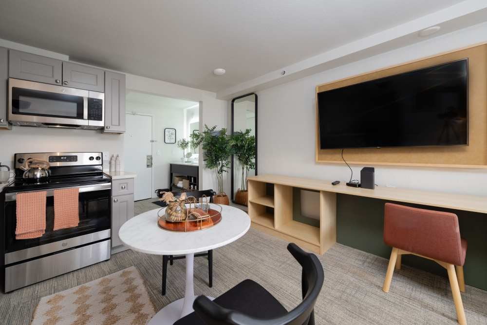 Furnished model apartment home with stainless steel appliances and flat screen TV at Thea Apartments in Tacoma, Washington.
