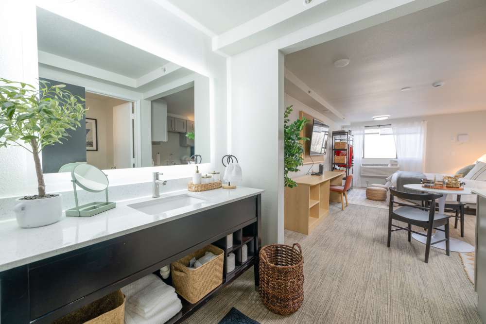 Full bathroom vanity with backlit mirror at Thea Apartments in Tacoma, Washington.
