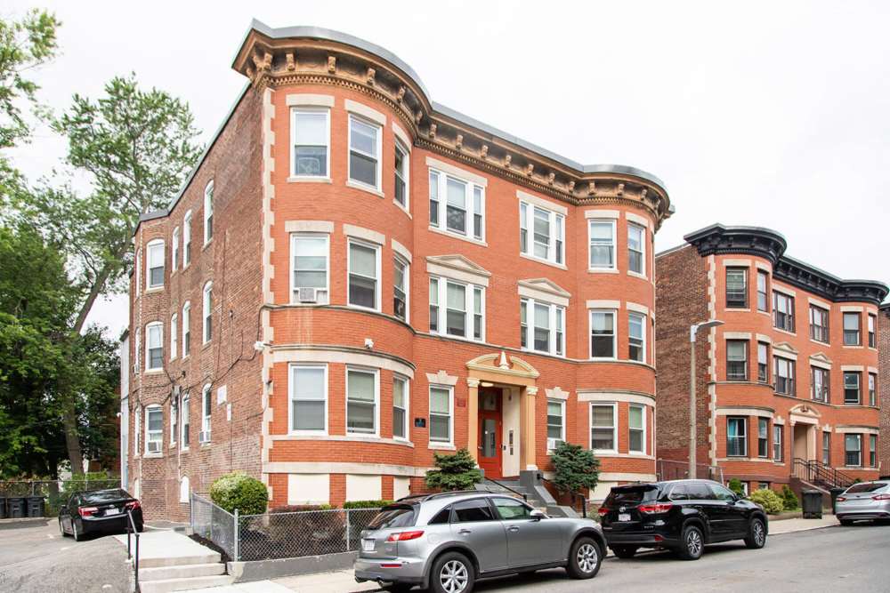 Corner view of the apartment with street parking facility at JPNDC Pitts Portfolio in Roxbury, Massachusetts