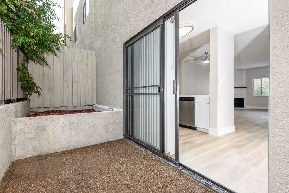 Patio with concrete flooring, planter box and large glass sliding door from kitchen at The Indie Glendale Collection in Glendale, California