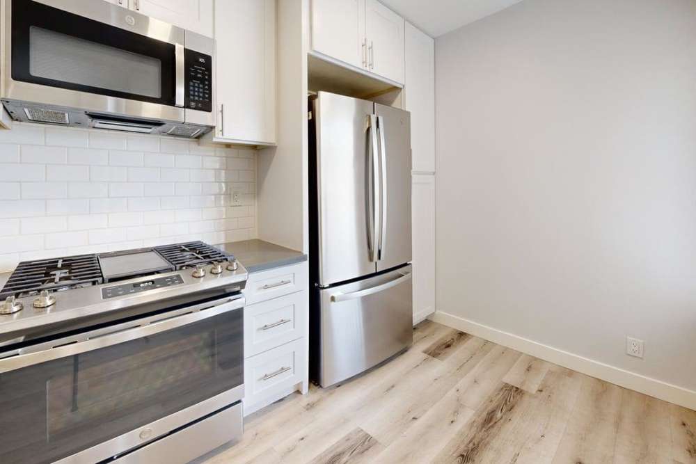 Fully equipped kitchen with steel range, microwave , refrigerator and wooden floor at The Indie Glendale Collection, Glendale, California 