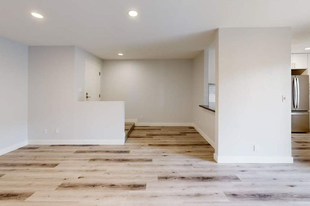  Living room with wood-style flooring  connecting to kitchen and dining area at The Indie Glendale Collection in Glendale, California