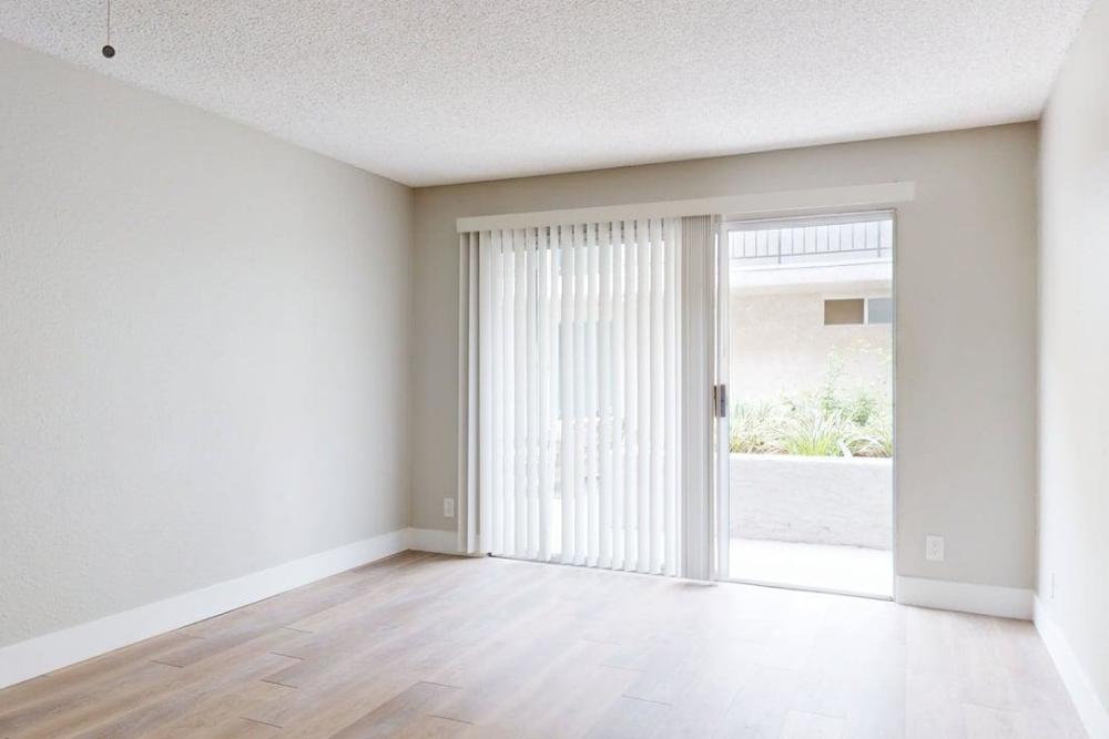 Empty living room with wood-style flooring with attached patio at The Indie Glendale Collection in Glendale, California