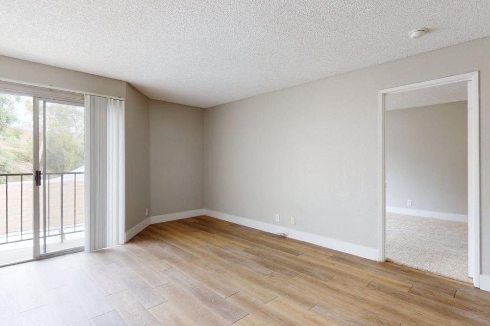 An empty living room with wood-style flooring with attached patio at The Indie Glendale Collection in Glendale, California