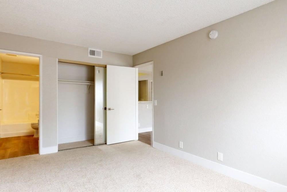 Empty bedroom with carpet flooring showing walkin type closet and attached bathroom at The Indie Glendale Collection in Glendale, California