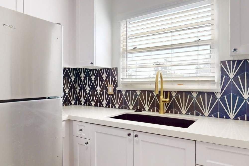 White cabinet kitchen with steel fridge and blue backsplash at The Indie Glendale Collection in Glendale, California