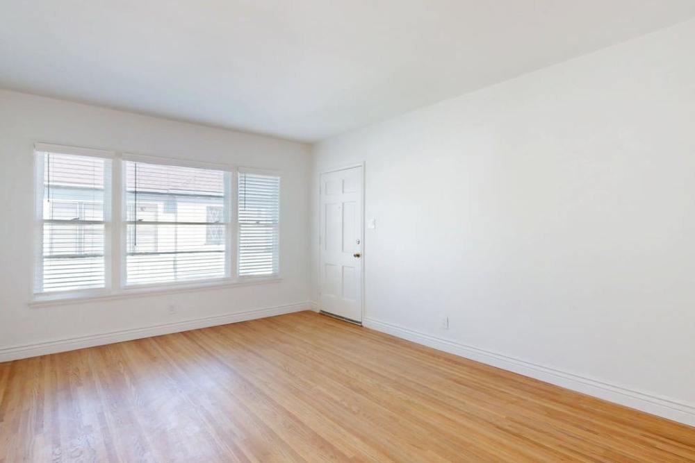 Empty living room with wood flooring and a window at The Indie Glendale Collection in Glendale, California