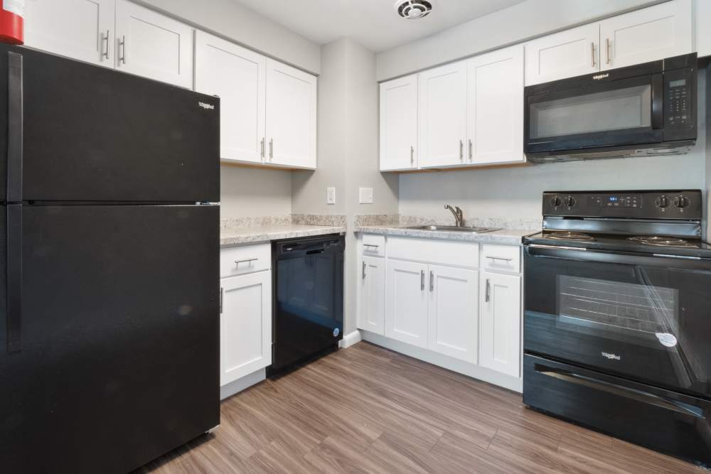 kitchen with white shaker cabinets and black appliances at Aston Pointe Apartments in Aston, Pennsylvania