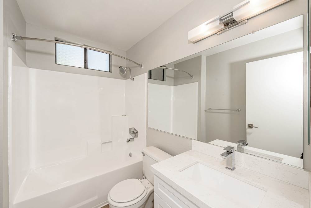 Modern bathroom with a sink, toilet, and shower at The Indie Glendale Collection in Glendale, California