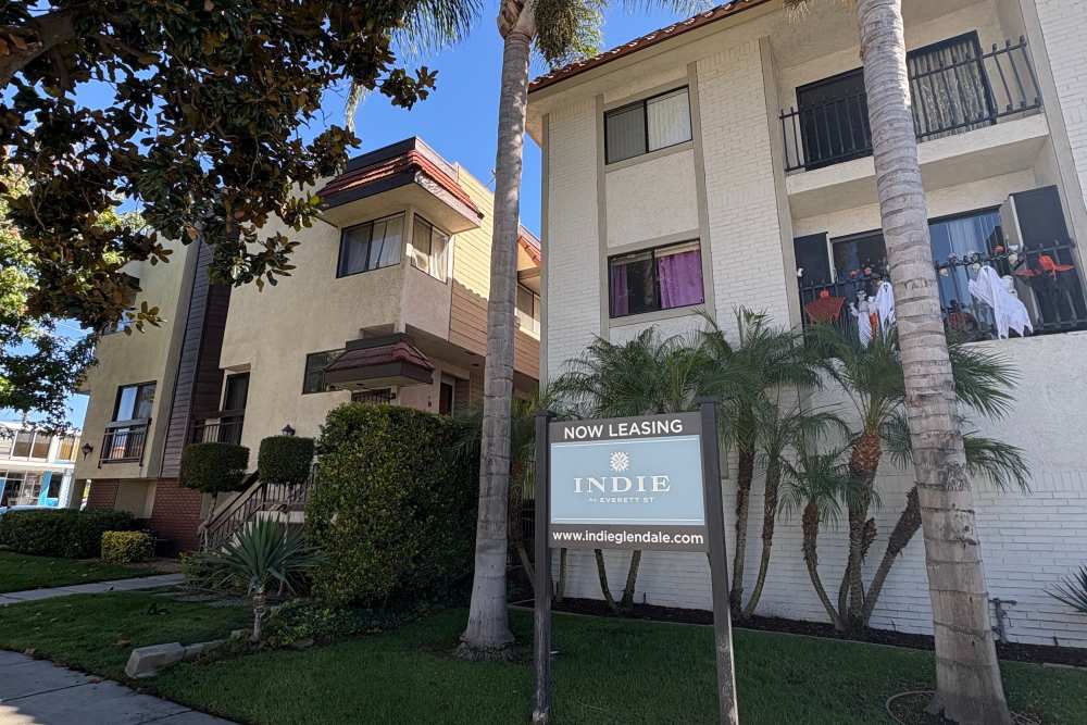 View of exterior of apartments and green lawn at The Indie Glendale Collection in Glendale, California