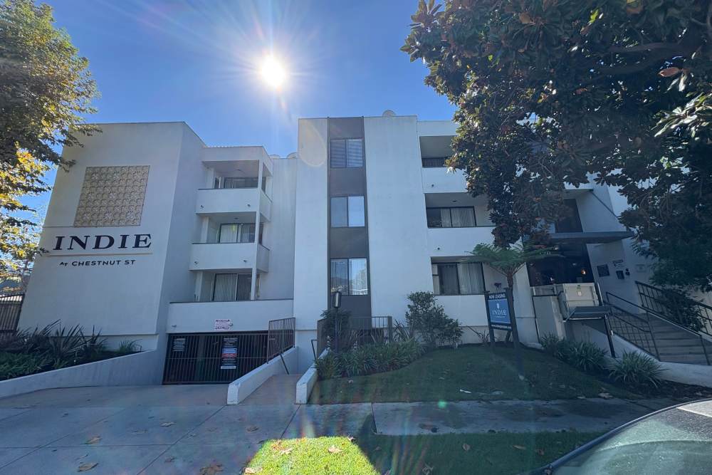 Entry view of community with walkway and lawn at The Indie Glendale Collection in Glendale, California