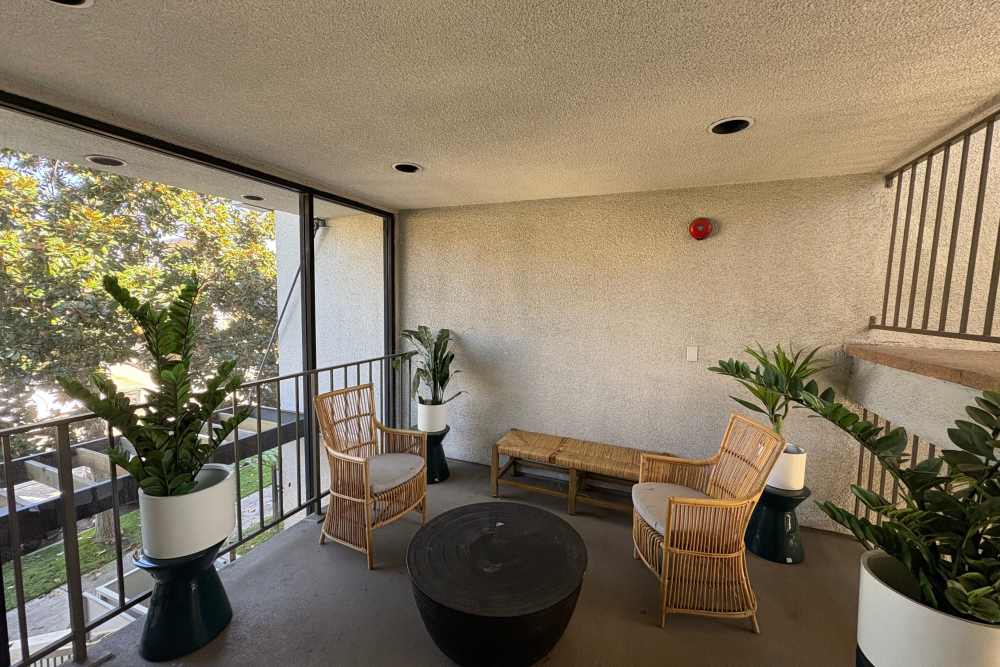 Balcony with cane seating and plants at The Indie Glendale Collection in Glendale, California