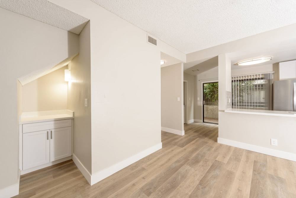 Bright dining room with wooden flooring, showing passthrough kitchen island at The Indie Glendale Collection in Glendale, California
