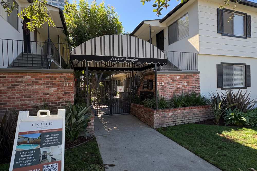 View of community entry with walkway and lawn at The Indie Glendale Collection in Glendale, California