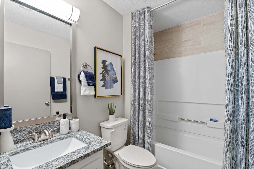  Stylish bathroom featuring white tub and curtain at Ascent Apartment Homes in Asheville, North Carolina