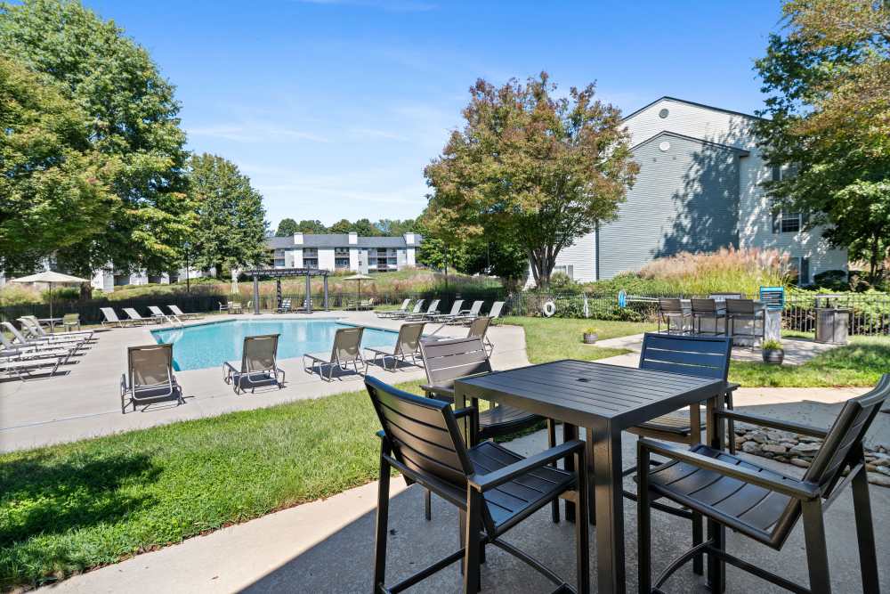 Outdoor dining table near apartment pool at Ascent Apartment Homes in Asheville, North Carolina