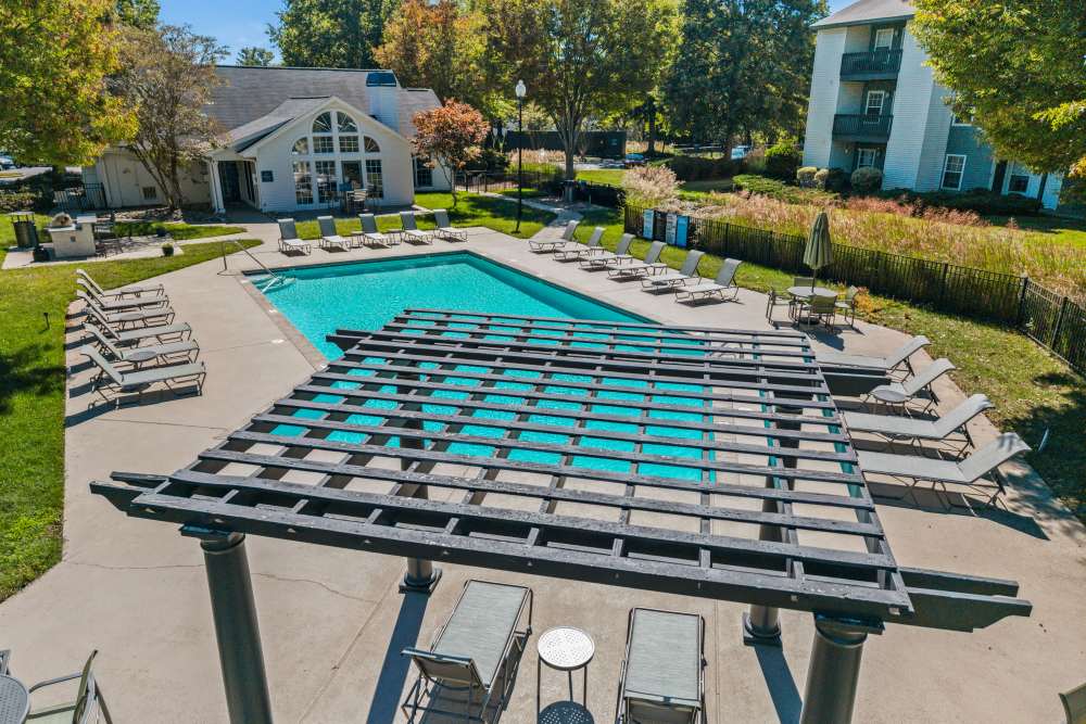 Apartment pool with pergola and lounge chairs at Ascent Apartment Homes in Asheville, North Carolina