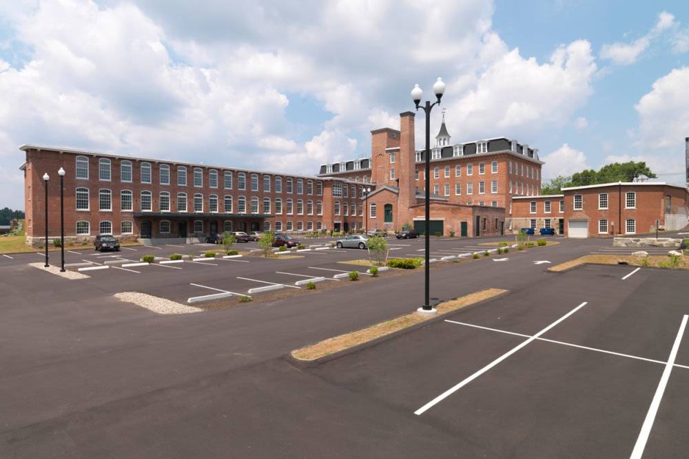Apartment exterior with outdoor parking at Linwood Mill Apartments in Whitinsville, Massachusetts