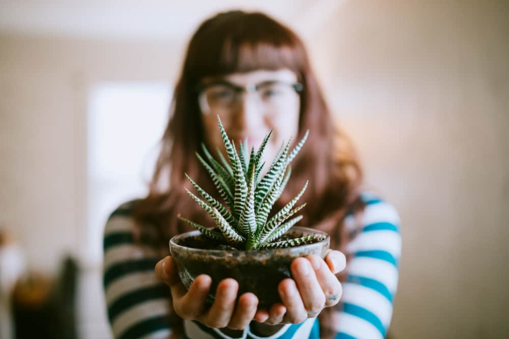 Resident woman holding a plant at The Palms in Gulfport,Mississippi