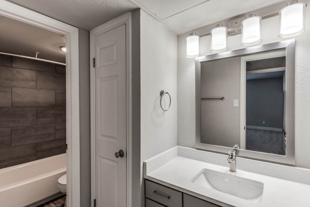 Bright bathroom with a large mirror at Warwick at Westchase in Houston, Texas