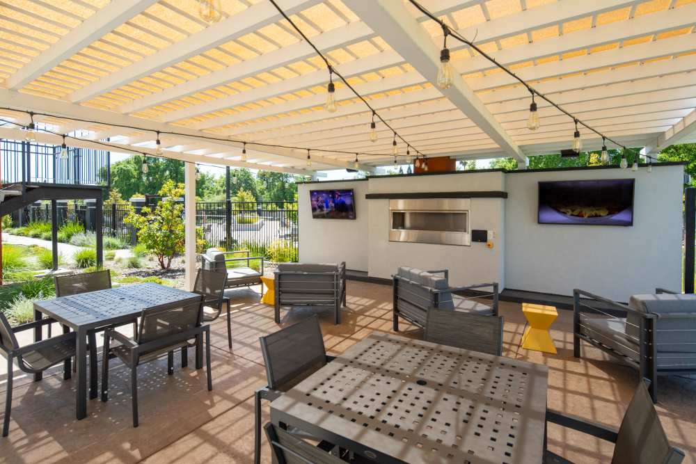 Outdoor canopy with fireplace, seating and outdoor tvs at Solasta in Sacramento, California
