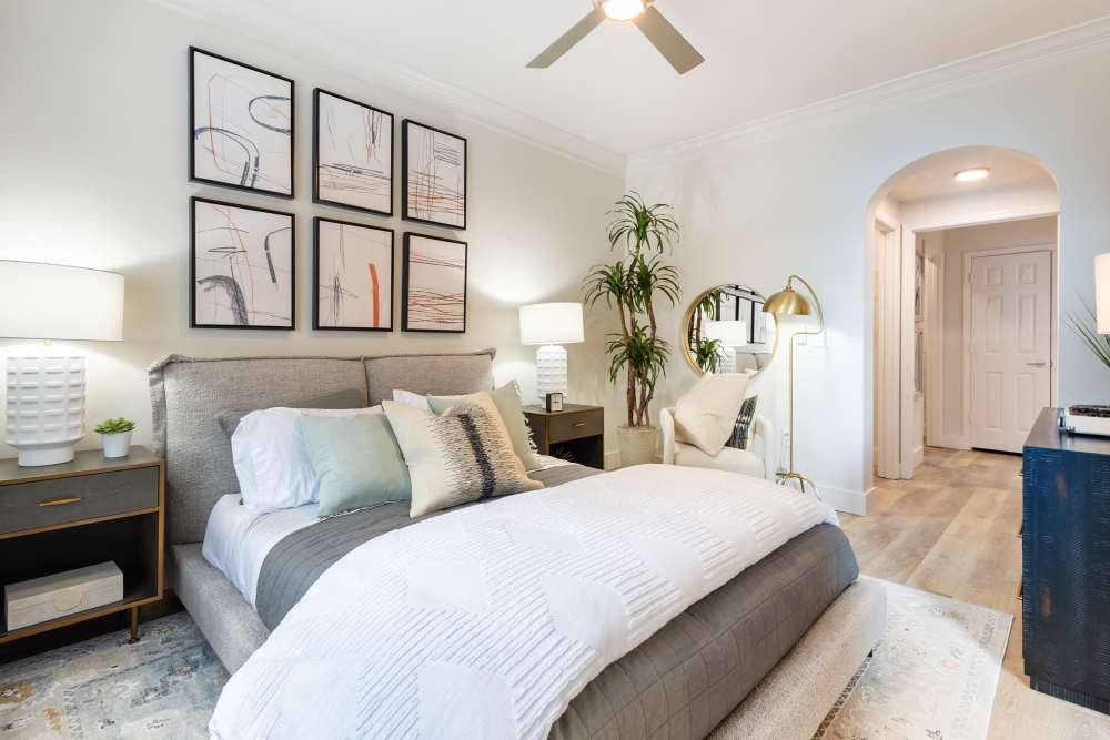 Modern bedroom with ceiling fan, bedside lamp and abstract painting at The Kinsley at Perimeter Center in Atlanta, Georgia